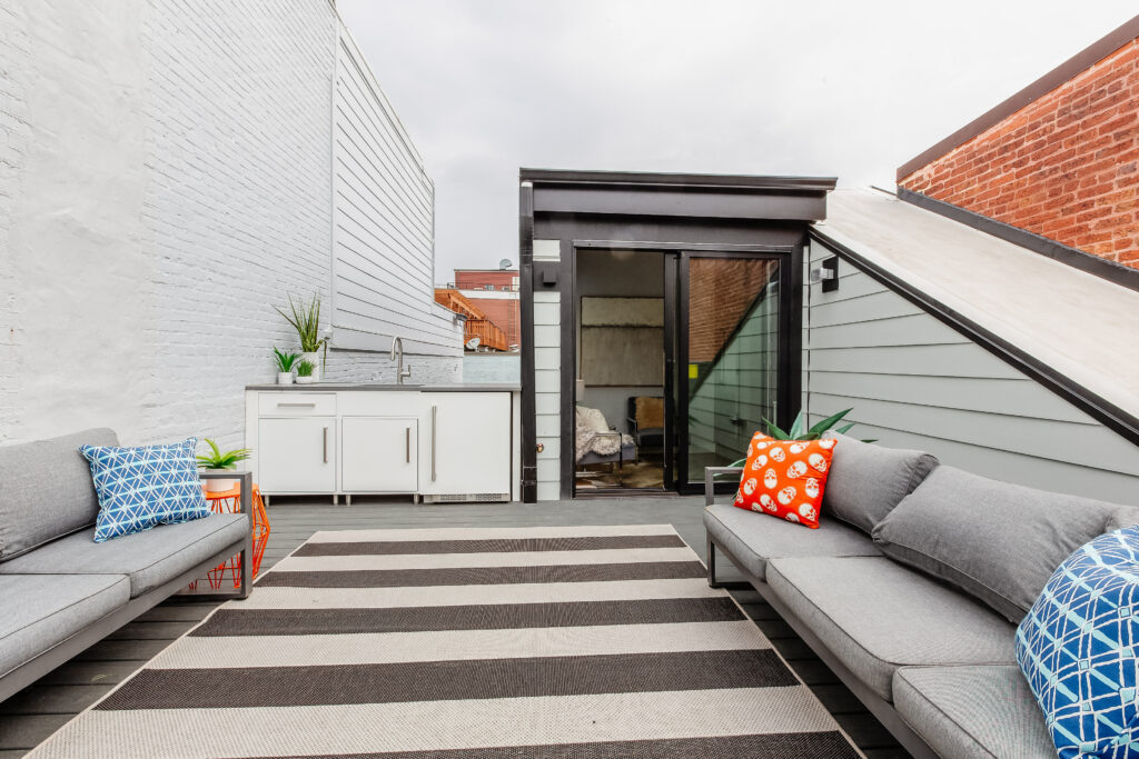 Rooftop terrace with two outdoor couches and a wet bar